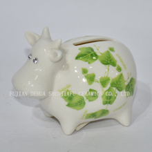 Petite vache en céramique avec décalcomanies vertes tirelire