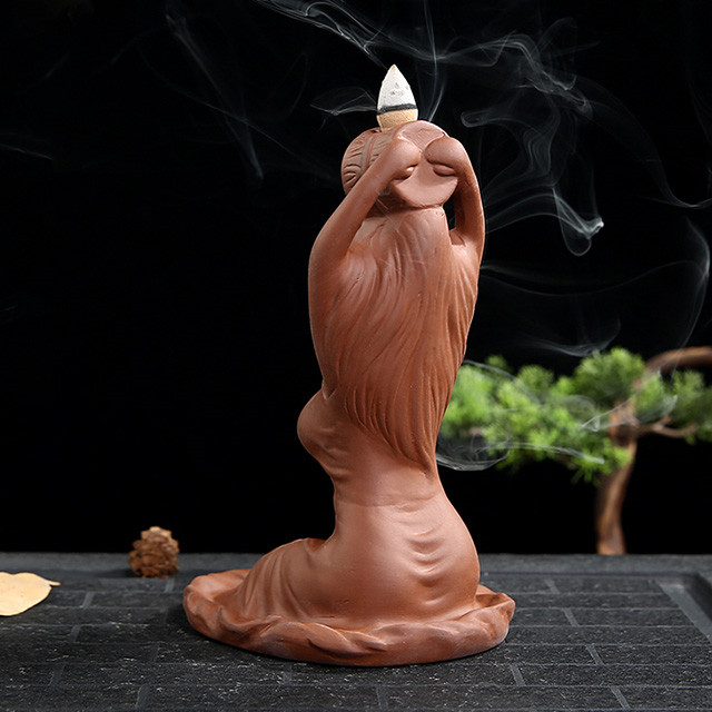 La déesse en céramique baigne le brûleur d'encens en céramique de reflux de parfum qui coule